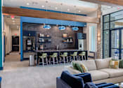 Thumbnail 14 of 36 - A modern living room with a bar area and a view of the outdoors.